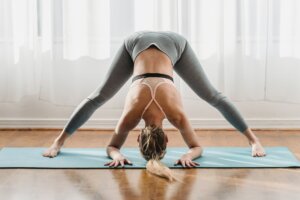 slim woman doing yoga in wide legged forward bend pose